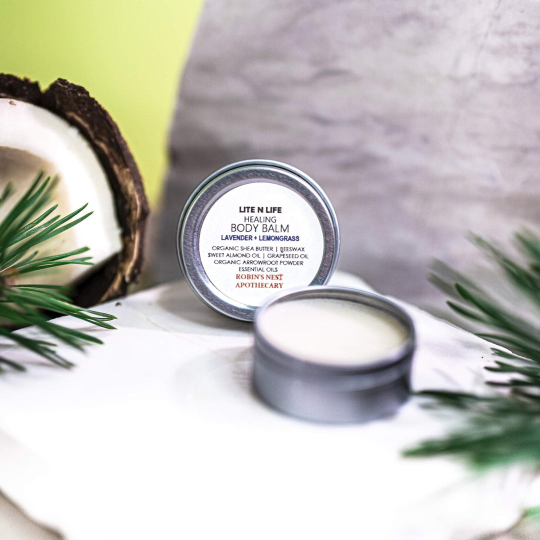 Healing body balm in a tin package with natural elements on a white surface