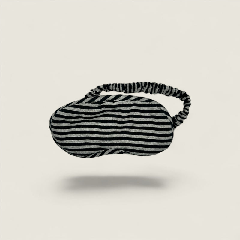 Striped eye mask on a light beige background