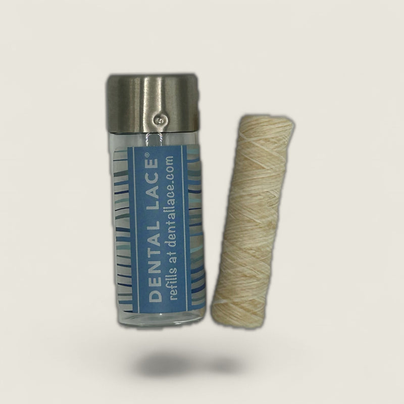 Dental lace packaging with a roll of beige dental lace on a light gray background