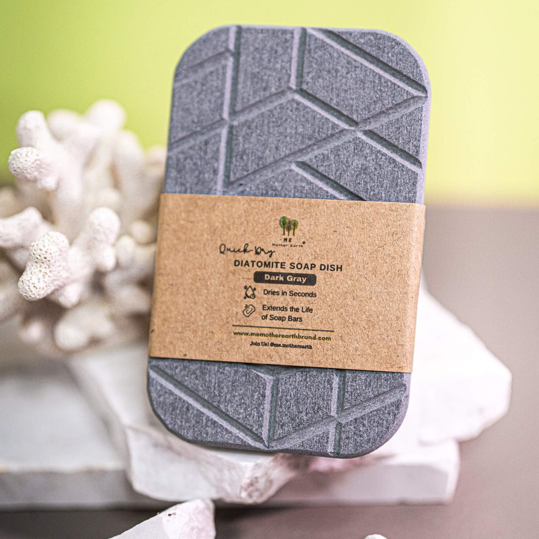 Gray Diatomite stone soap dish with a cardboard label on a white surface with coral-like decorations.