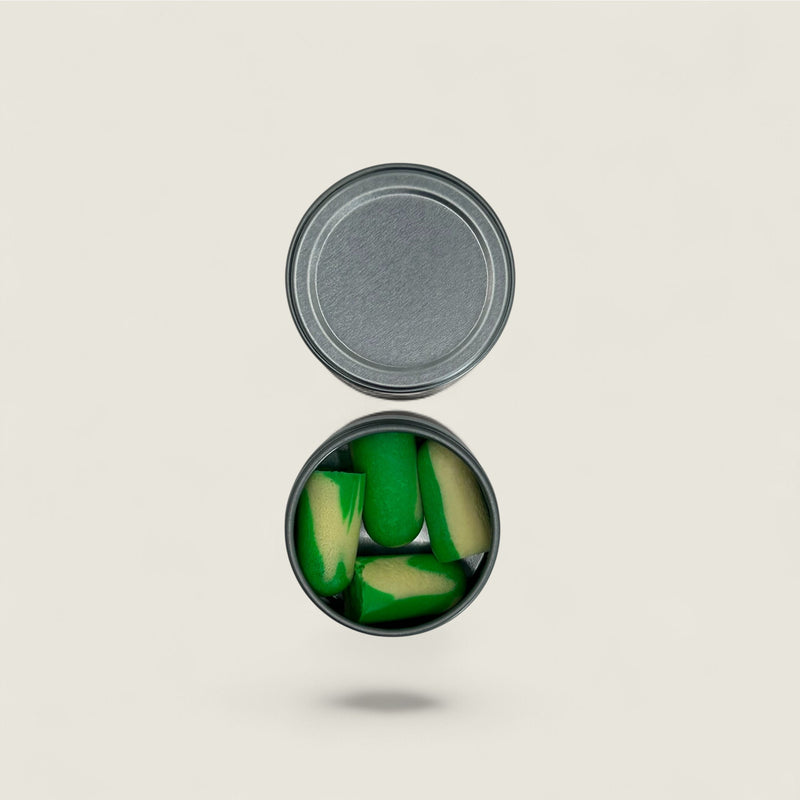 Open can of green ear plugs on a beige background