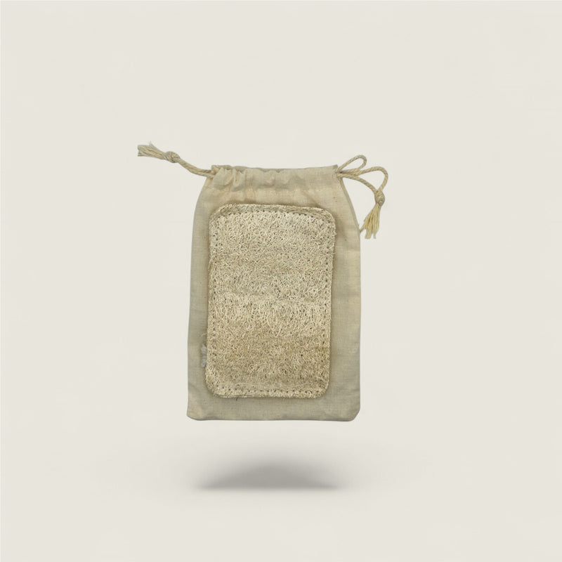Rectangular natural loofa in a drawstring pouch on a light beige background