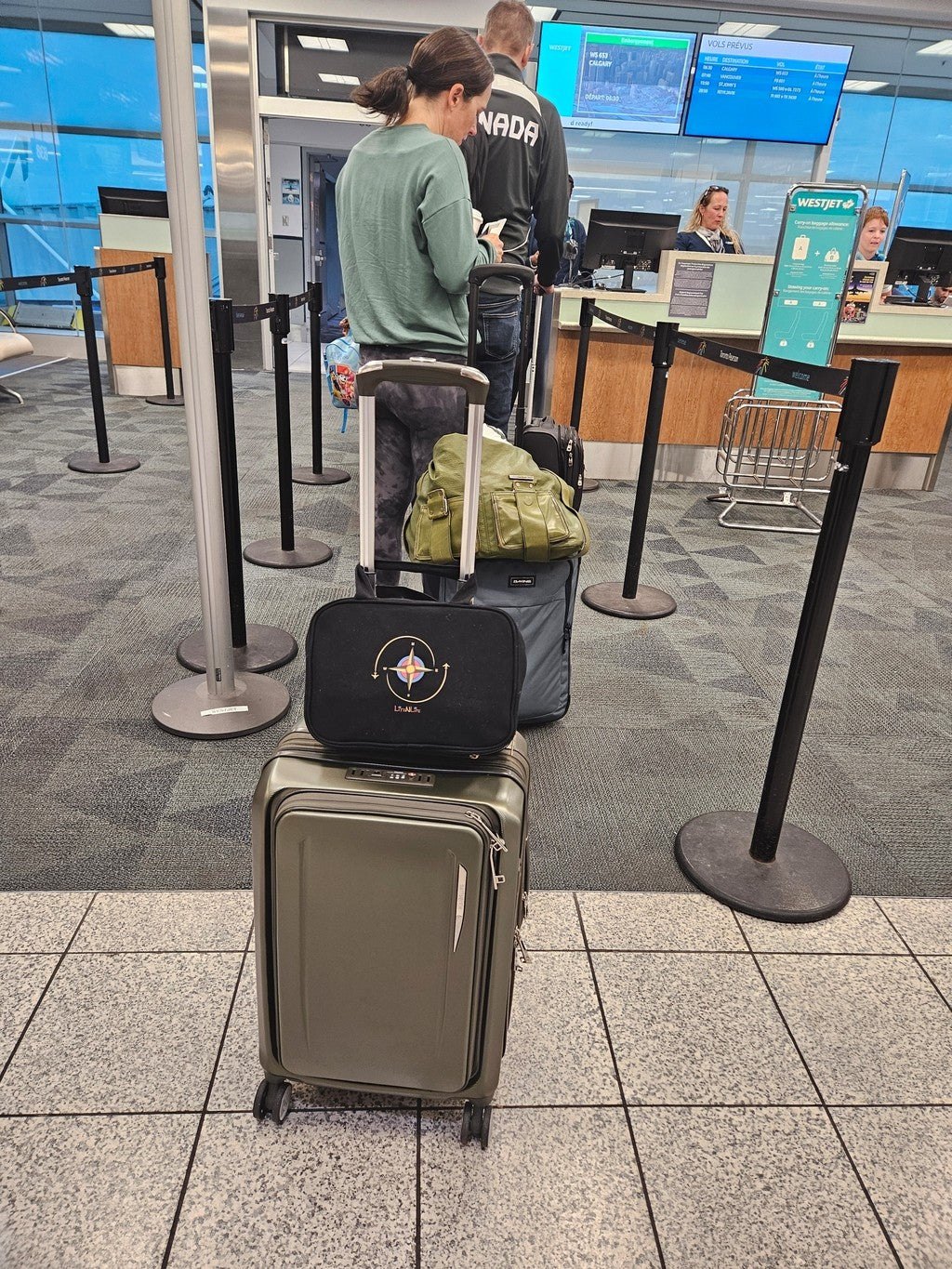 Person with luggage and lite n life travel kit at an airport check-in counter